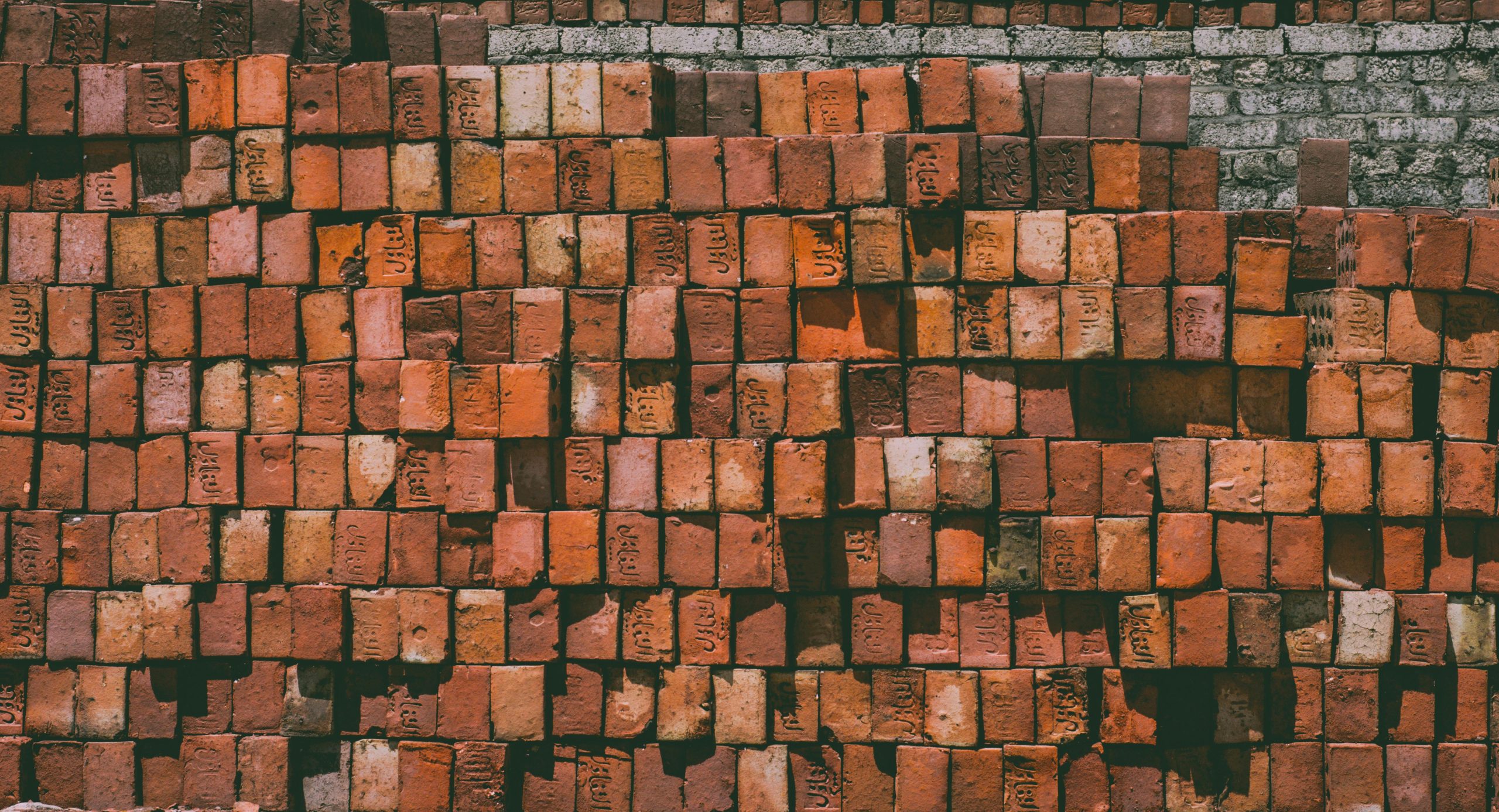 A detailed view of stacked red bricks forming a textured wall, showcasing brickwork pattern.